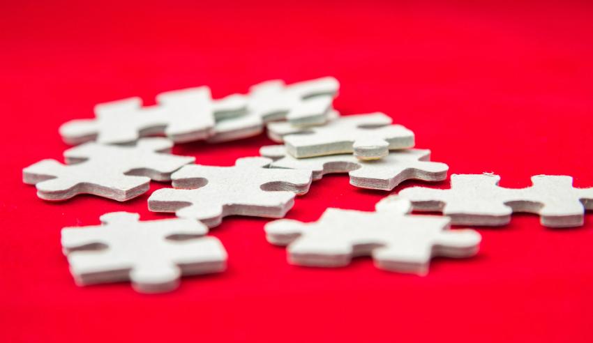 white puzzle pieces on red table mid tier law firm closing shop dibbsbarker joining dentons