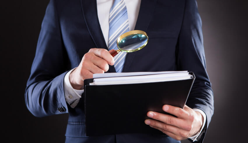 Magnifying glass, payroll tax fraud
