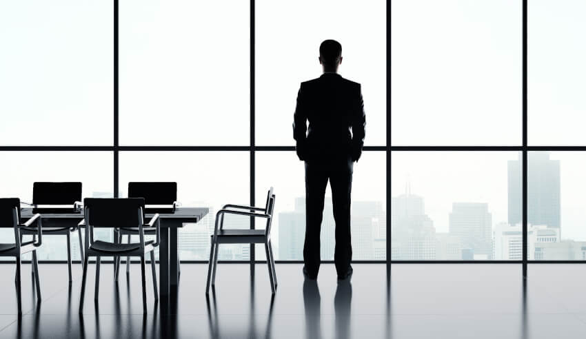 businessman standing in office and looking in city
